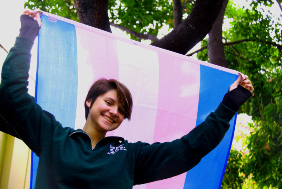 Transgender student Alex Nyholm-Goncalves, who identifies as gender non-conforming, holds up the trans flag with pride. 