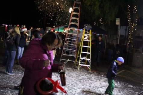 People play in the fake snow pumped out by snow machines.