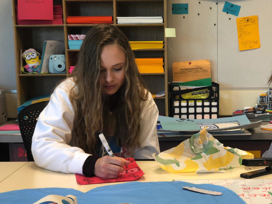 Sasha Belov, a freshman, works on a poster for the Snowman Project.