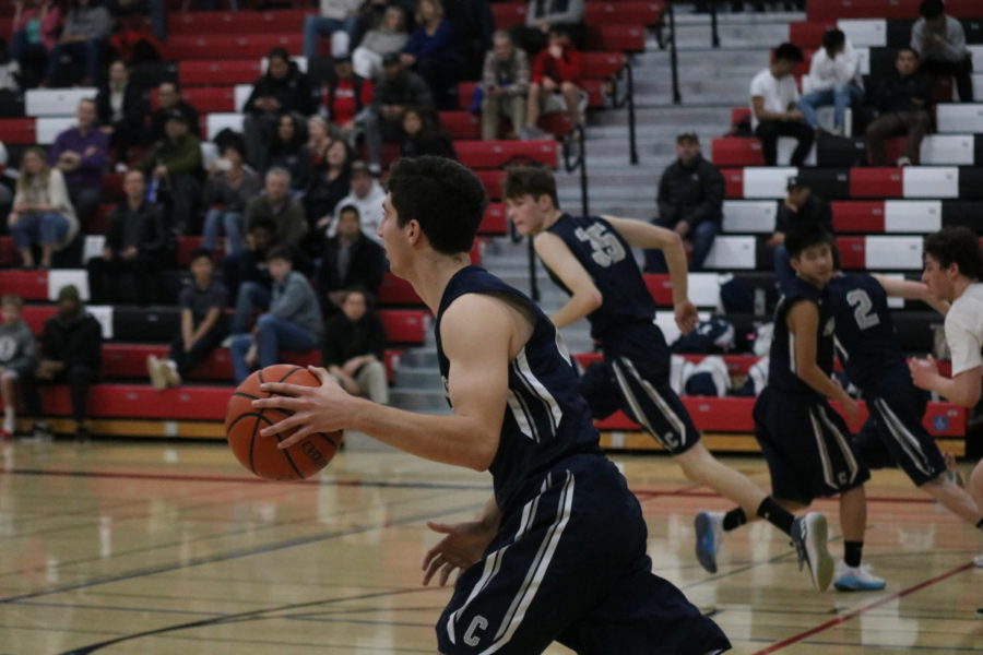 David Bedrosian, a senior and point forward, takes the ball down the court.