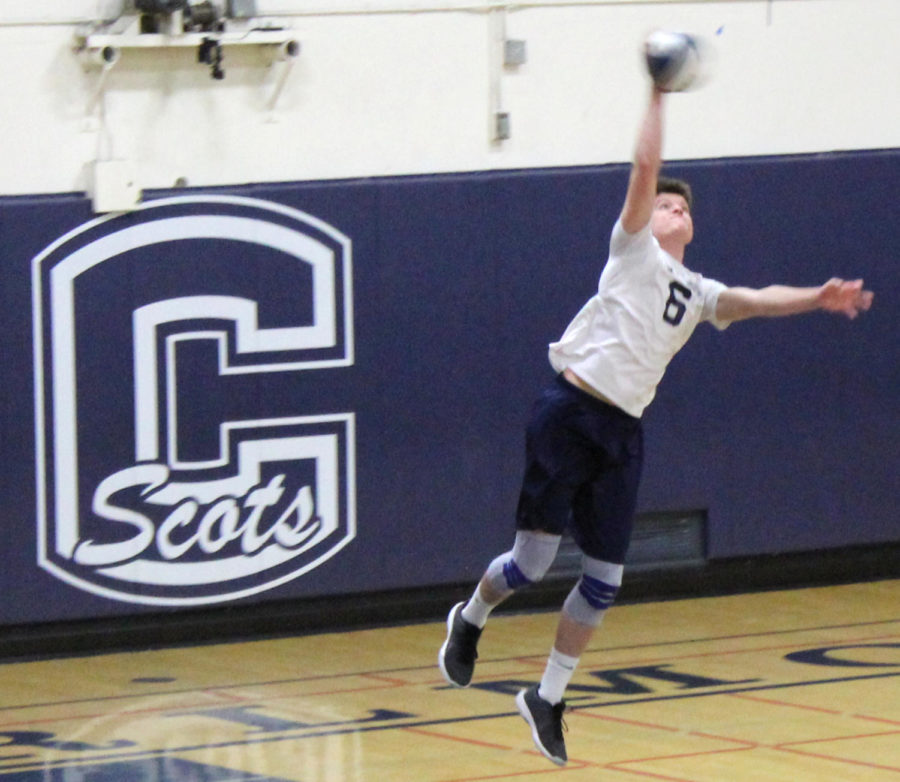 Ethan Mayoss, a junior, serves the ball during the first match