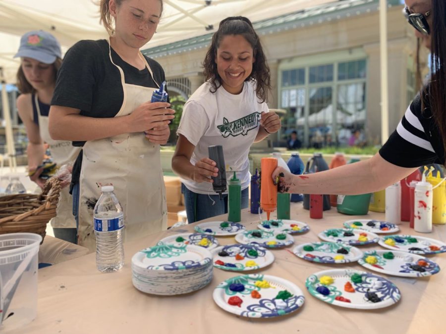CAPA volunteers graciously squirt different colored paint onto paper plates.