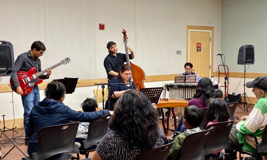 Enrique+Rojas+on+guitar%2C+Alex+Farrell+on+bass%2C++Mark+Davis+on+trumpet%2C+and+Shura+Taylor+on+guzheng+are+performing+in+the+Belmont+Library.