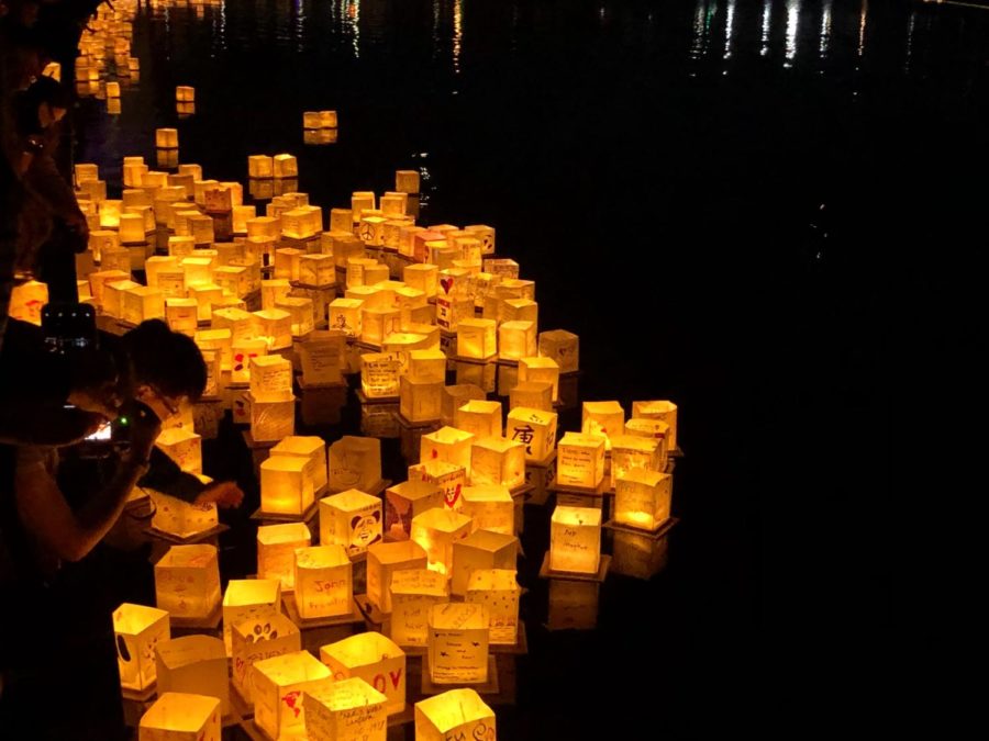 Lanterns are placed in the water as they begin to light up the festival