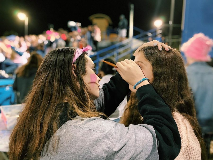 At the football game, a student gets her face painted pink in honor of Breast Cancer Awareness week.