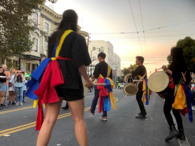 Korean drummers take over Valencia Street to perform in solidarity with protesters from five years earlier.