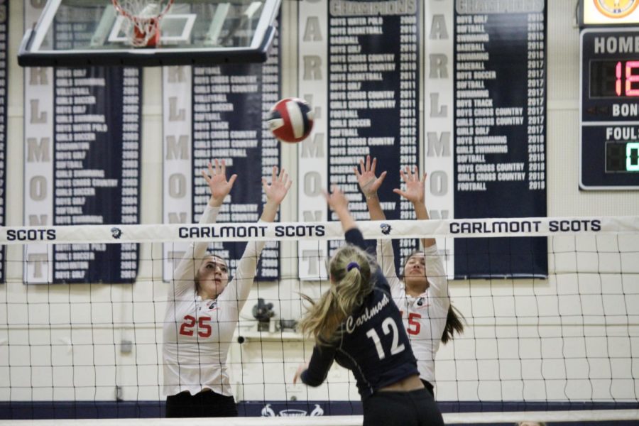 Sophomore Sasha Belov goes up to attack against two blockers.