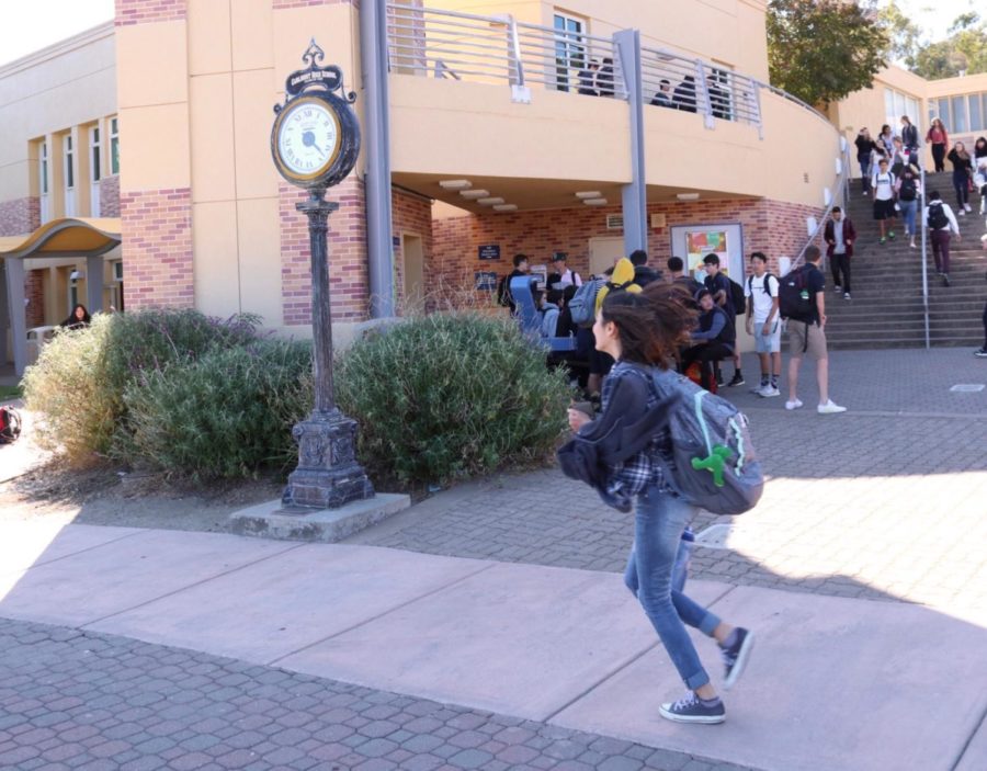 A student rushes to class as the one-minute bell rings.