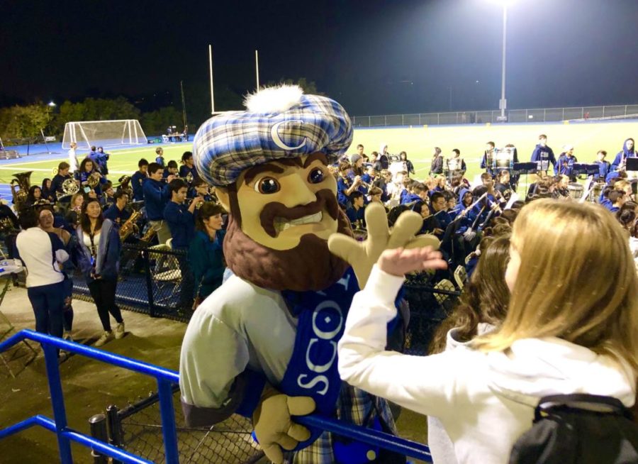 Carlmonts Mascot, Monty, gives out high fives in the football stands.