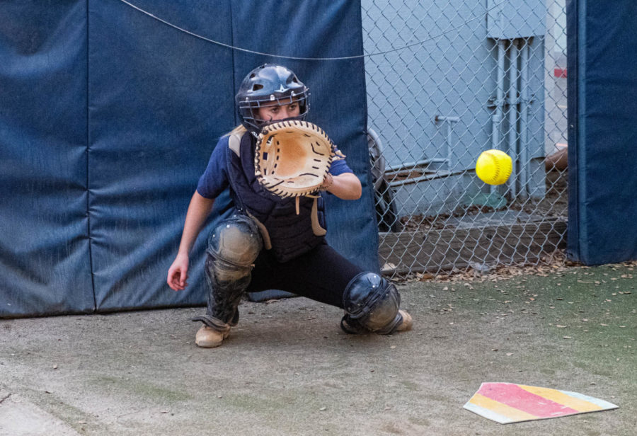 Dana Knoble, a junior, catches a ball during pitching practice.