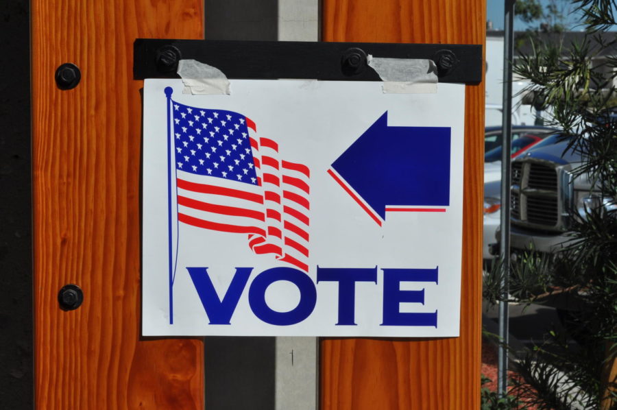 A sign points to a nearby polling place in California. The Voters Choice Act makes it easier for voters to cast their ballots.