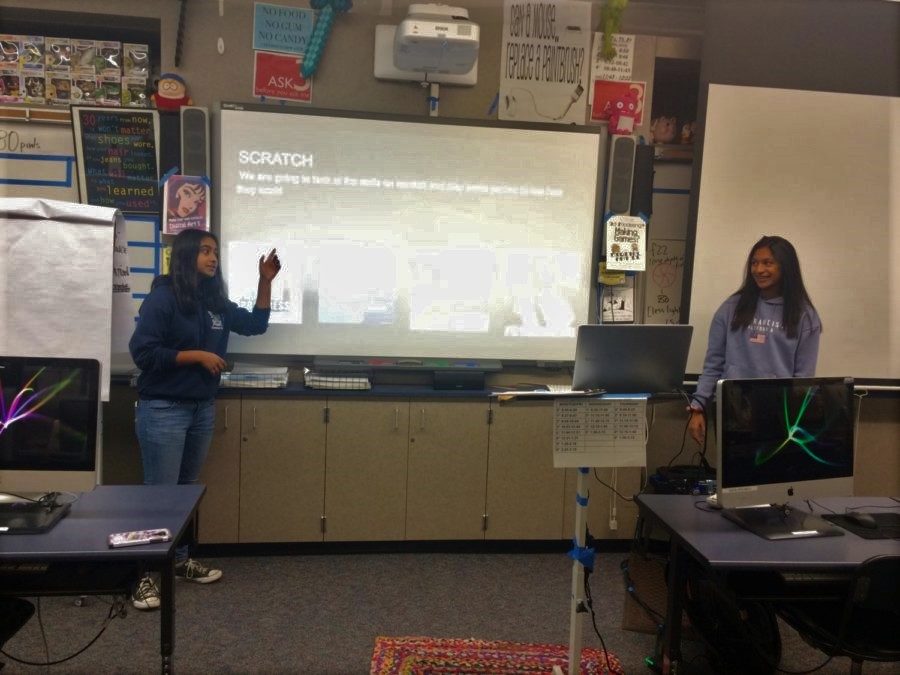 Club leaders Raina Lahiri and Amisha Nambiar give a presentation during a club meeting. Coding related memes are added to the presentation to engage club members.