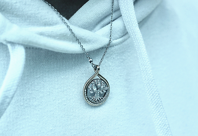 Elly Xus necklace is a symbol of a silver tree, with the roots representing her parents and the branches as herself and her brother.