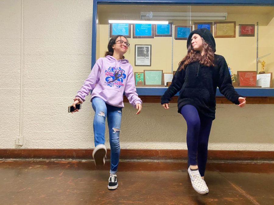 Freshmen Anna Passos and Emily Hall practice the Cupid Shuffle during lunch. 