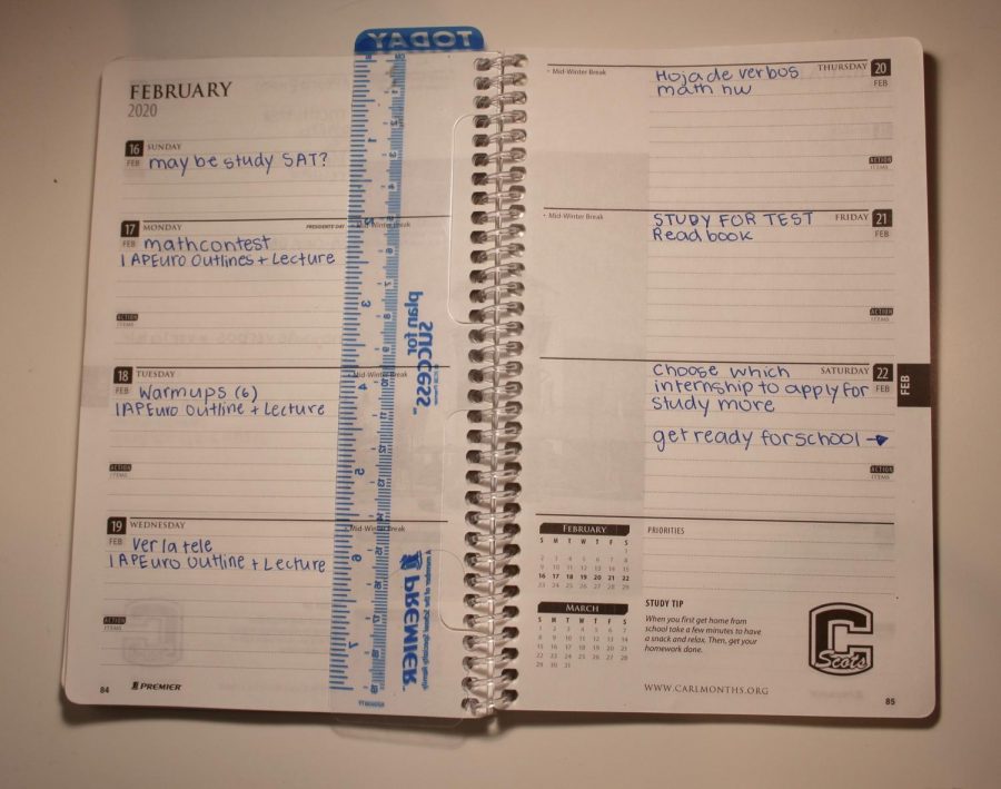 A student spreads out their work for the week in their planner in order to balance work and relaxing.