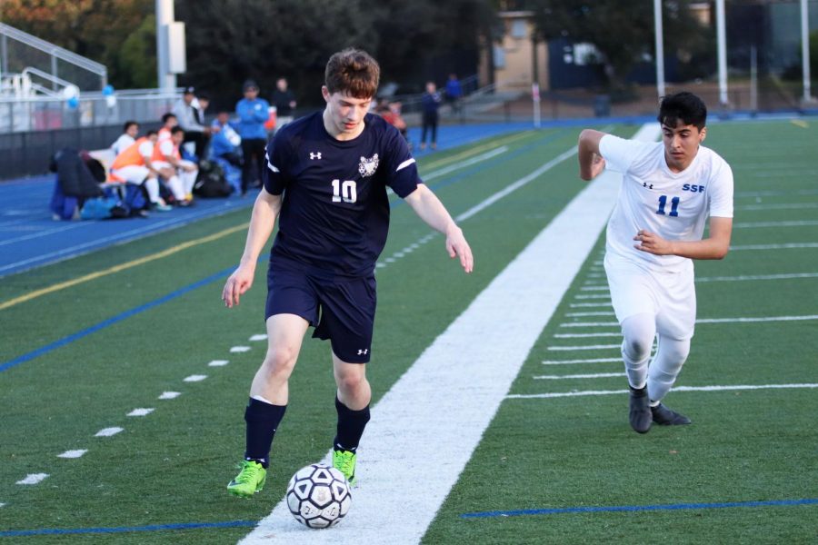Dylan Roskind, a junior, dribbles the ball down the sideline and past a defender.