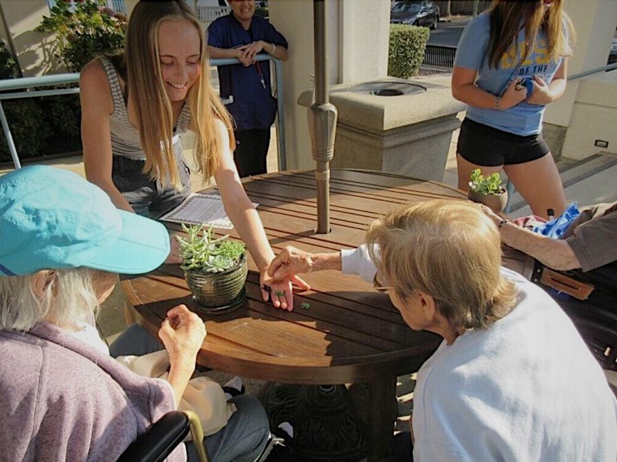 Elle Brough, the club president, hands out succulent pots to the elderly.