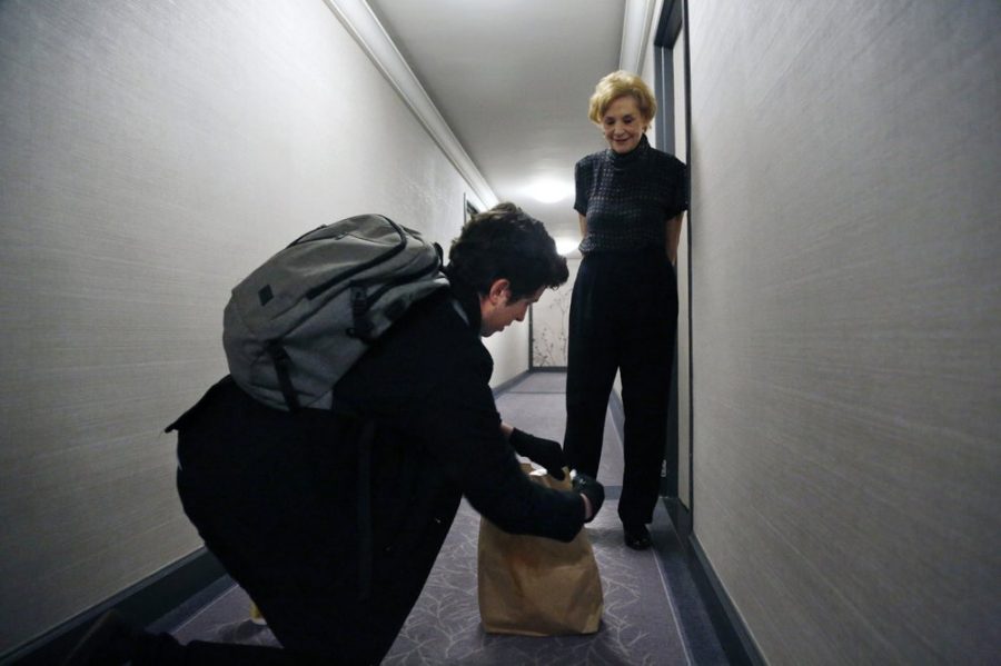 Liam Elkind, a co-founder of the Invisible Hands operation, delivers groceries for Carol Sterling.