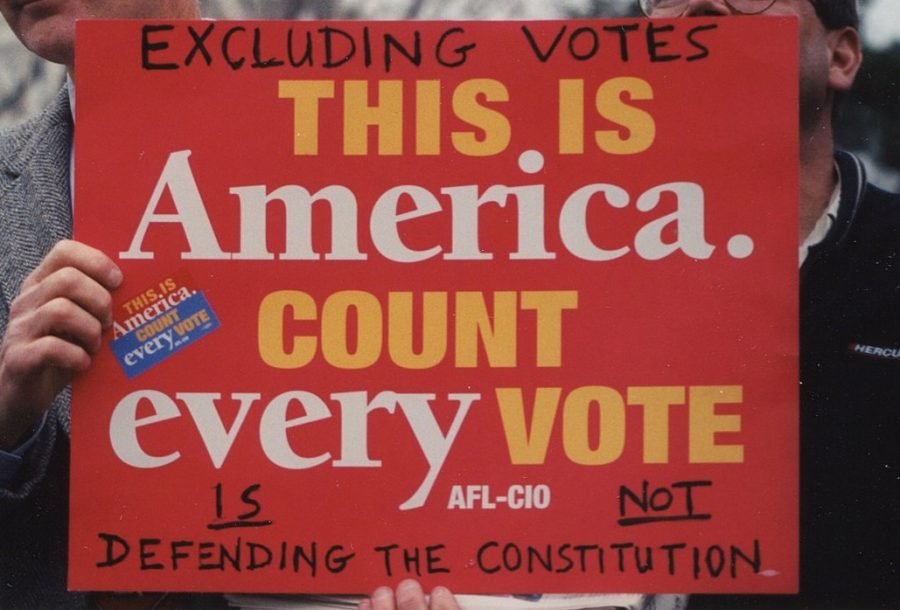 A person holds up a sign protesting the Electoral College system and the outcome of the 2000 election.