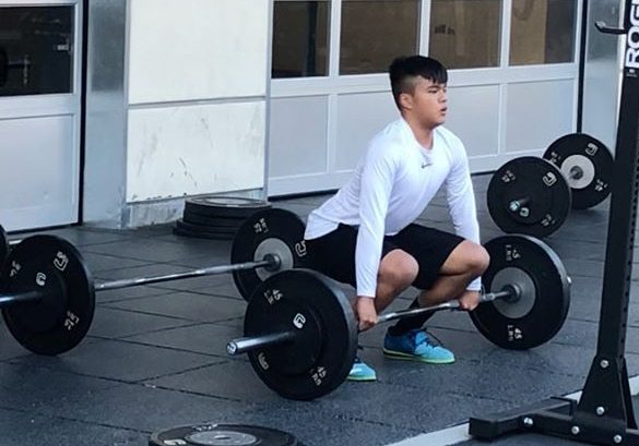Joshua Yglesias, a junior, cleans weights. Despite the practice restrictions, the Carlmont football team is able to have some activity, such as lifting weights.