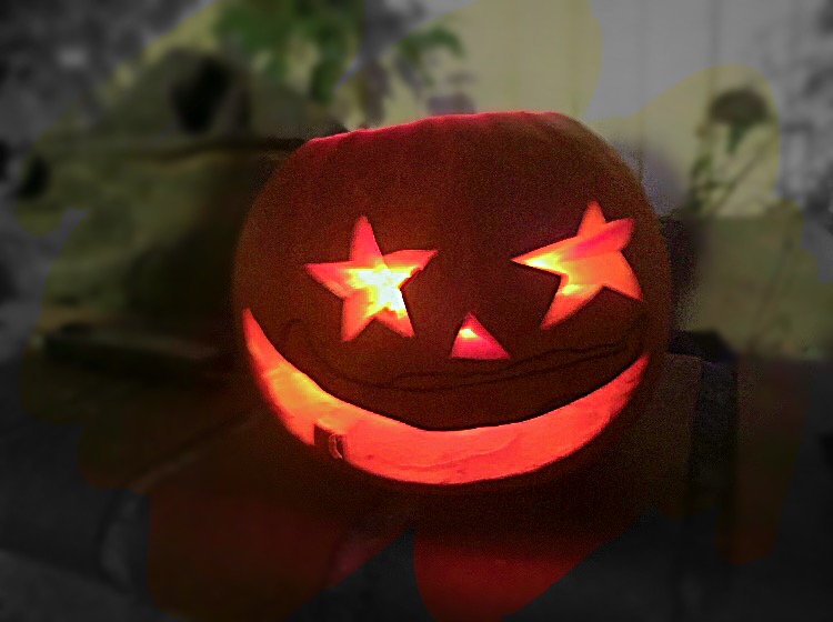 Dan Teng celebrates Halloween by setting a carved pumpkin in his backyard.