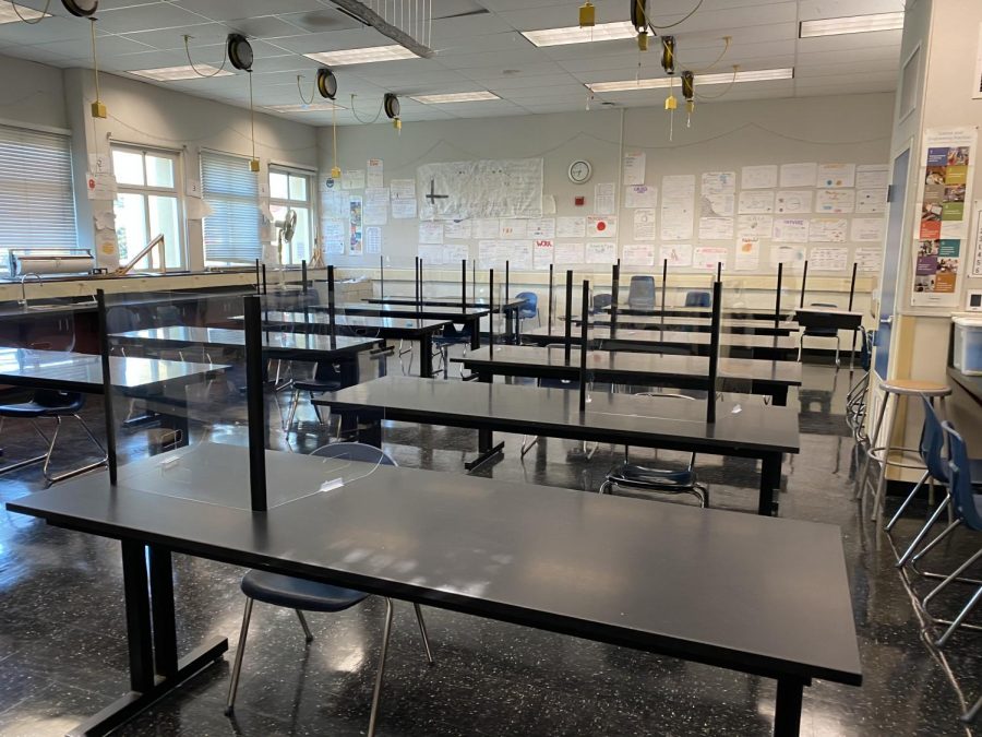 A classroom at Carlmont High School demonstrates precautions being taken for educational cohorts. It has plexiglass partitions at each desk, with seats measured 6 feet apart from each other.