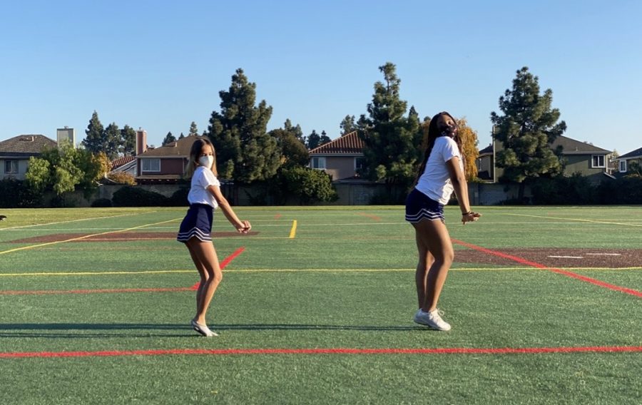 Sophomore cheerleaders Maya Brazil and Maliya Anderson practice a dance outdoors.