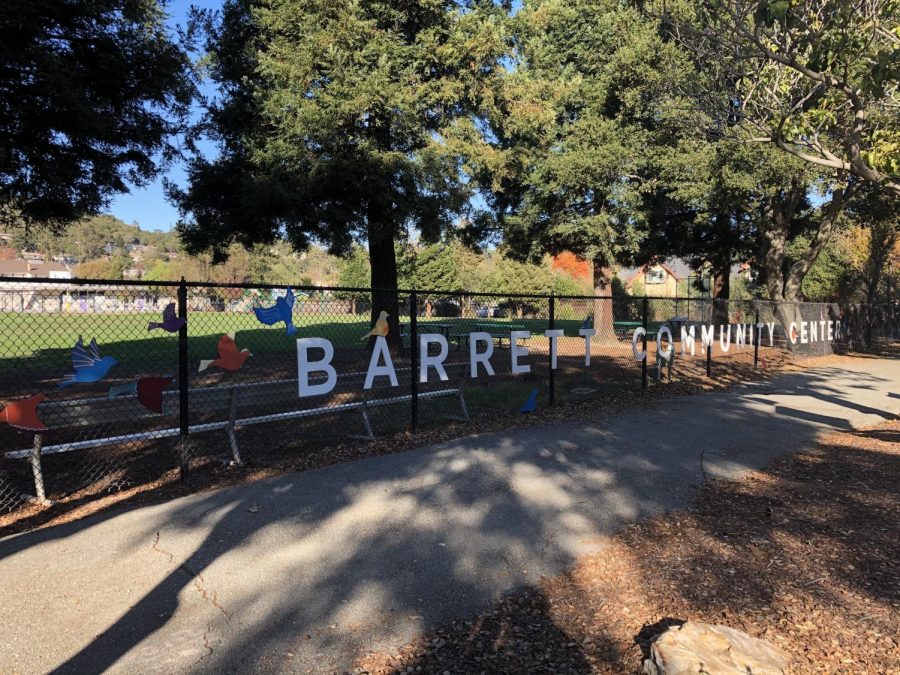 The Barrett Community Center sign features artwork showing many birds flying around the words as a decorative addition to the fence. 