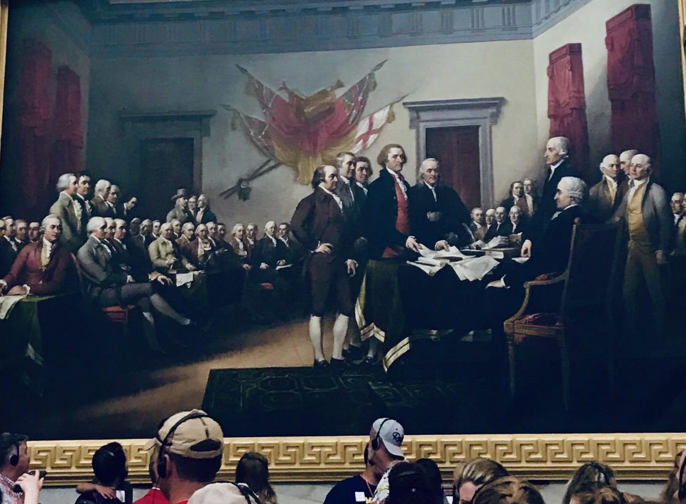 Visitors at the capitol building observe a painting of the Constitutional Convention, where the Founding Fathers used negotiations to form our nation.