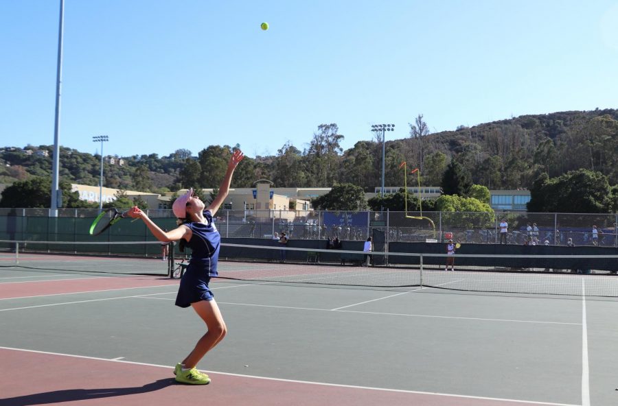 Chloe Khachadourian, a Carlmont freshman, tosses a ball overhead, preparing to serve during warm-ups. 
