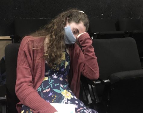 A student leans on their wrist as they start to fall asleep in class.