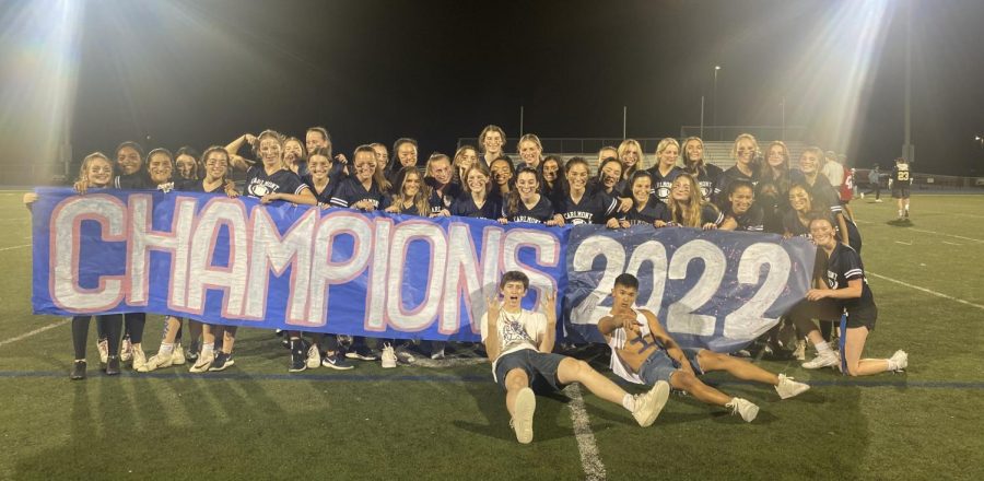The senior powderpuff team poses with their banner after winning the championship game.
