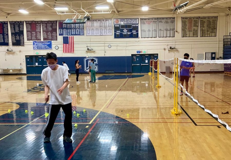 Joshua Ting, a junior, serves the birdie in a practice match at a Carlmont open gym.