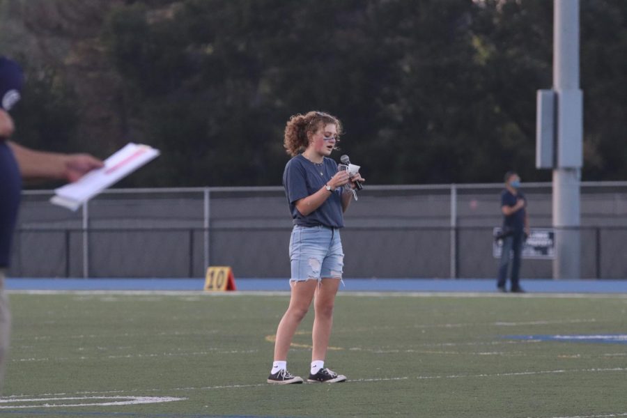 Molli Shields sings the National Anthem at a football game.
