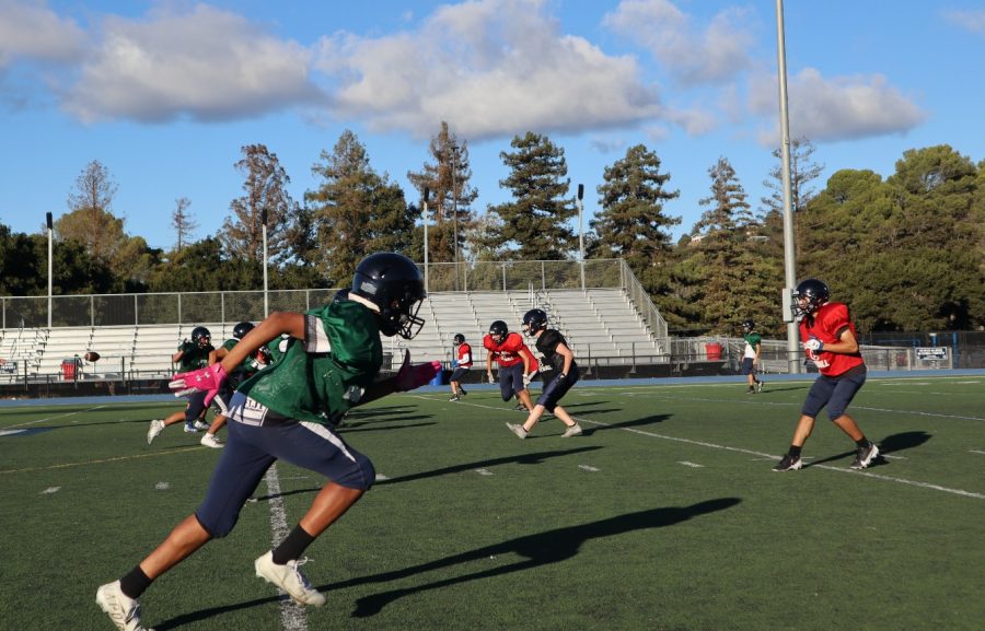 At an after-school practice, players run a drill to prepare their defense for the next game.