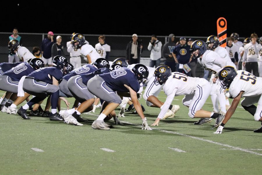Carlmont's quarterback sets up behind the offensive line as they prepare to hike the ball.