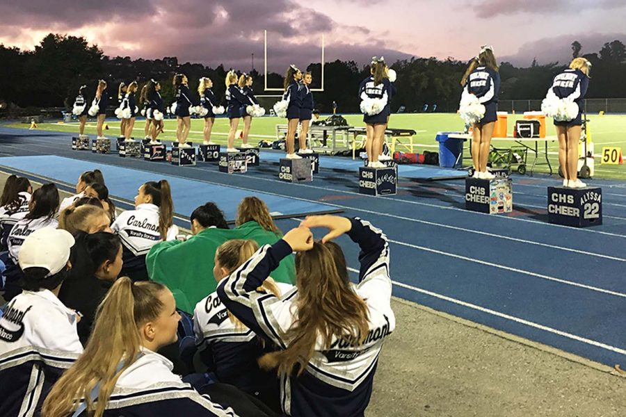 Cheerleaders line the edge of the football field during a football game in 2019.