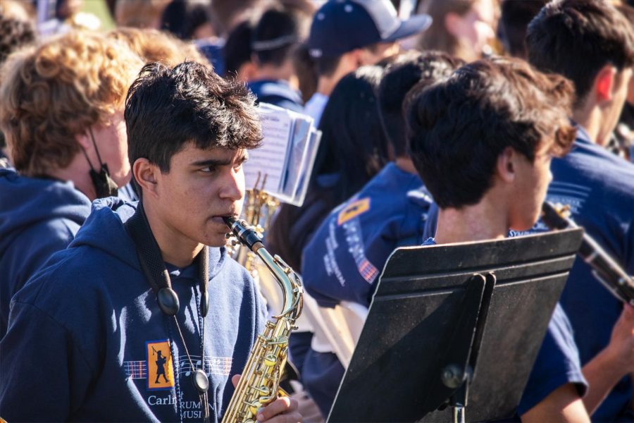 A saxophone player plays with pep band during an assembly. 