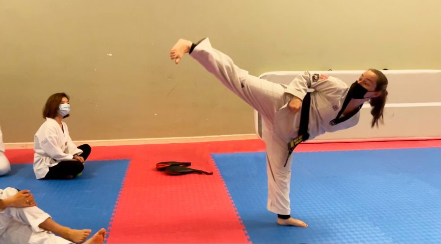 Meggie Presti, owner of Core Taekwondo, demonstrates a kick technique to her teen class. 