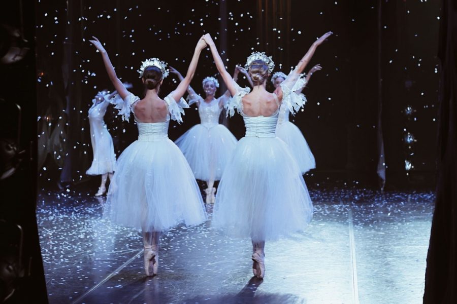 Dancers come out of the wings of the stage to perform in the snow scene of the Nutcracker.