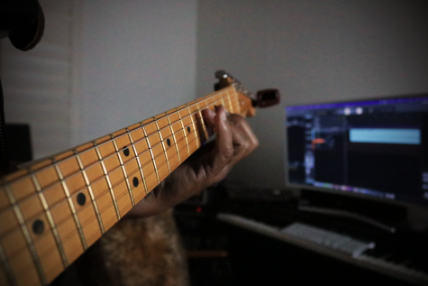A musician plays guitar in a studio apartment
