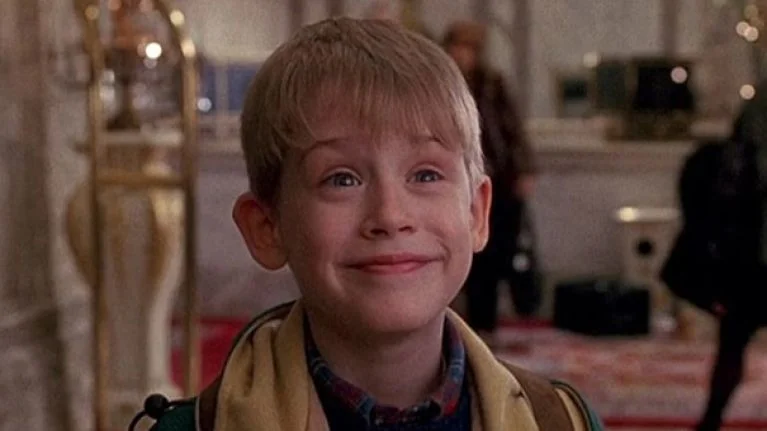Kevin, the main character in Home Alone, smiling at the camera.