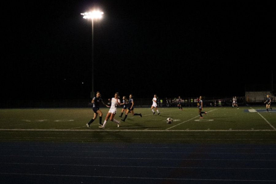 Scots and Tigers redirect themselves towards the ball amidst the glaring stadium lights.