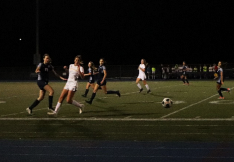Scots and Tigers redirect themselves towards the ball amidst the glaring stadium lights.