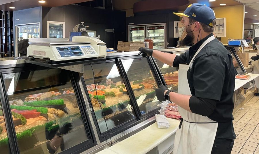 Bryan Gilbert, an employee at Papes Meat Co., serves a customer buying fish in the seafood section. “I’ve worked here a long time, and my personal favorite food besides the crab is the steak,” Gilbert said.