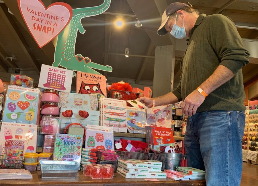 A Paper Source shopper browses a Valentines Day displays card options.