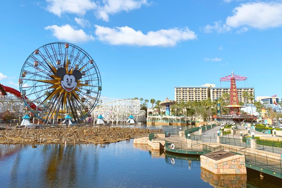 Disneylands iconic Mickey Mouse Ferris Wheel shines across the water, reflecting Disneys past and influence.
