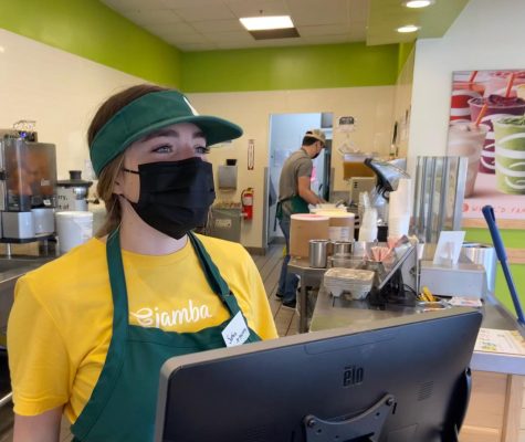 Employees working in a Carlmont Village Shopping Center restaurant wear masks while they take orders and prepare food.