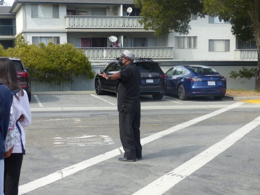 Donald Newt holds traffic before ushering students safely across the street. 
