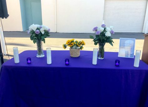 CORA organizes a remembrance service for Karina Castro to unite the community against domestic violence. The setup follows a purple theme due to the color representing domestic violence awareness.